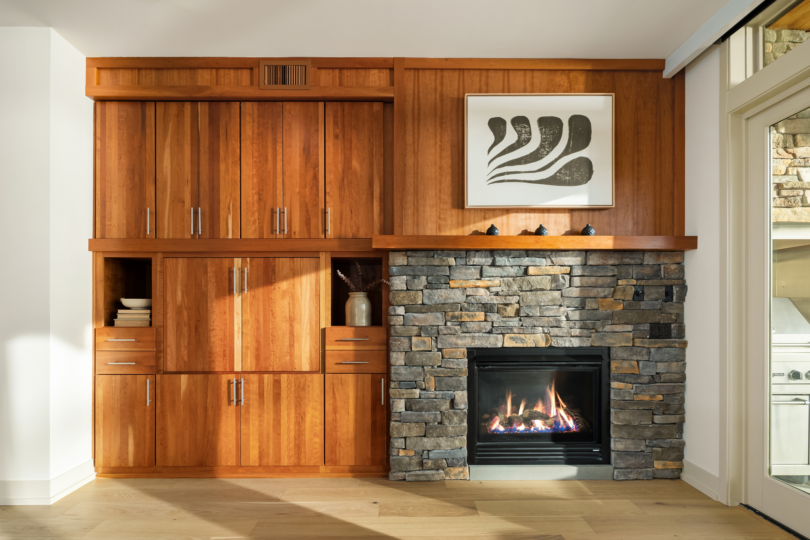 Stone fireplace detail with custom wood cabinetry